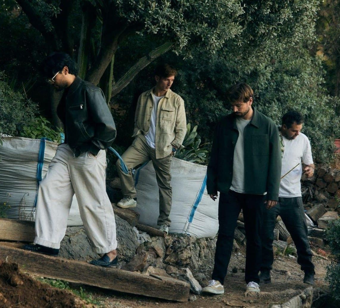 Cuatro arquitectos bajan por el jardín de la obra entre sacos y piedras