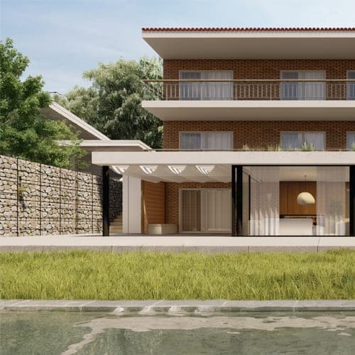 Fachada de IM10: casa de tres plantas con balcones, planta baja acristalada, piscina y muro de gaviones